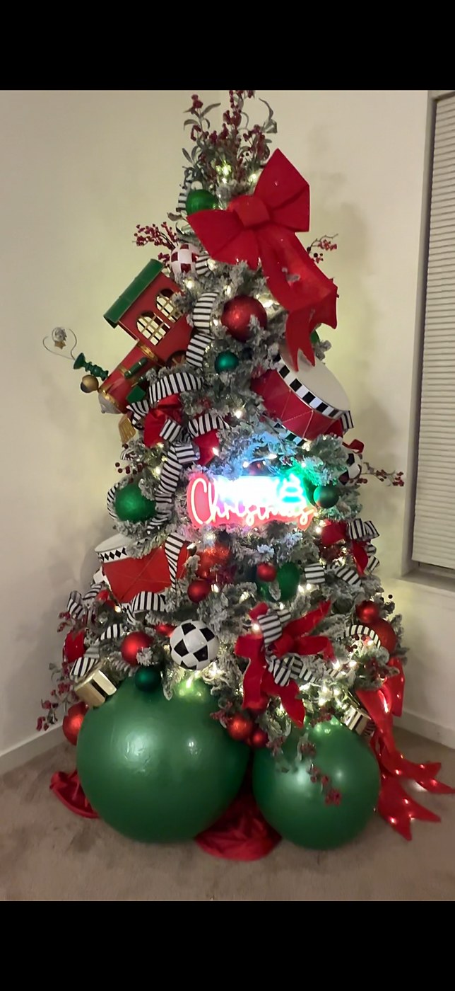 Whimsical red and green Christmas tree with toy details and a neon Christmas sign