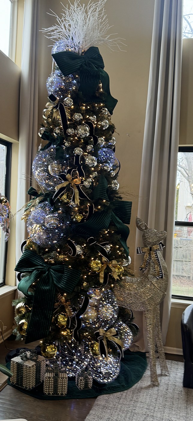 Emerald green Christmas tree with silver ornaments and a glittered reindeer figure